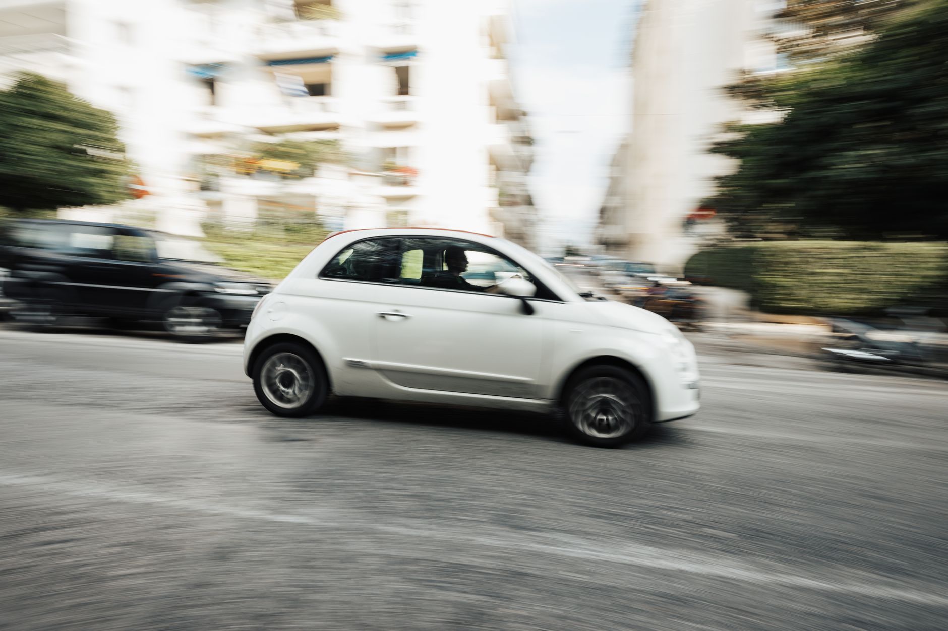 Biała Skoda Citigo w ruchu na miejskiej ulicy z efektem rozmycia