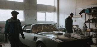 Mechanicy przy zabytkowym samochodzie w garażu podczas renowacji