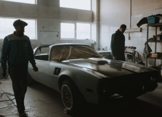 Jak zacząć przygodę z klasykami PRL: wybór pierwszego auta, budżet renowacji i gdzie szukać części Mechanicy przy zabytkowym samochodzie w garażu podczas renowacji