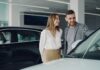 Uśmiechnięta para ogląda samochód Honda w salonie samochodowym