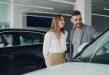Którą Hondę wybrać do 50 tys. Uśmiechnięta para ogląda samochód Honda w salonie samochodowym