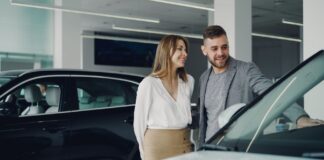 Uśmiechnięta para ogląda samochód Honda w salonie samochodowym