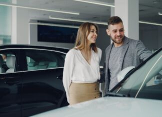 Którą Hondę wybrać do 50 tys. Uśmiechnięta para ogląda samochód Honda w salonie samochodowym