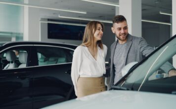 Którą Hondę wybrać do 50 tys. Uśmiechnięta para ogląda samochód Honda w salonie samochodowym