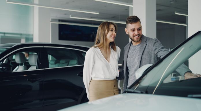 Uśmiechnięta para ogląda samochód Honda w salonie samochodowym