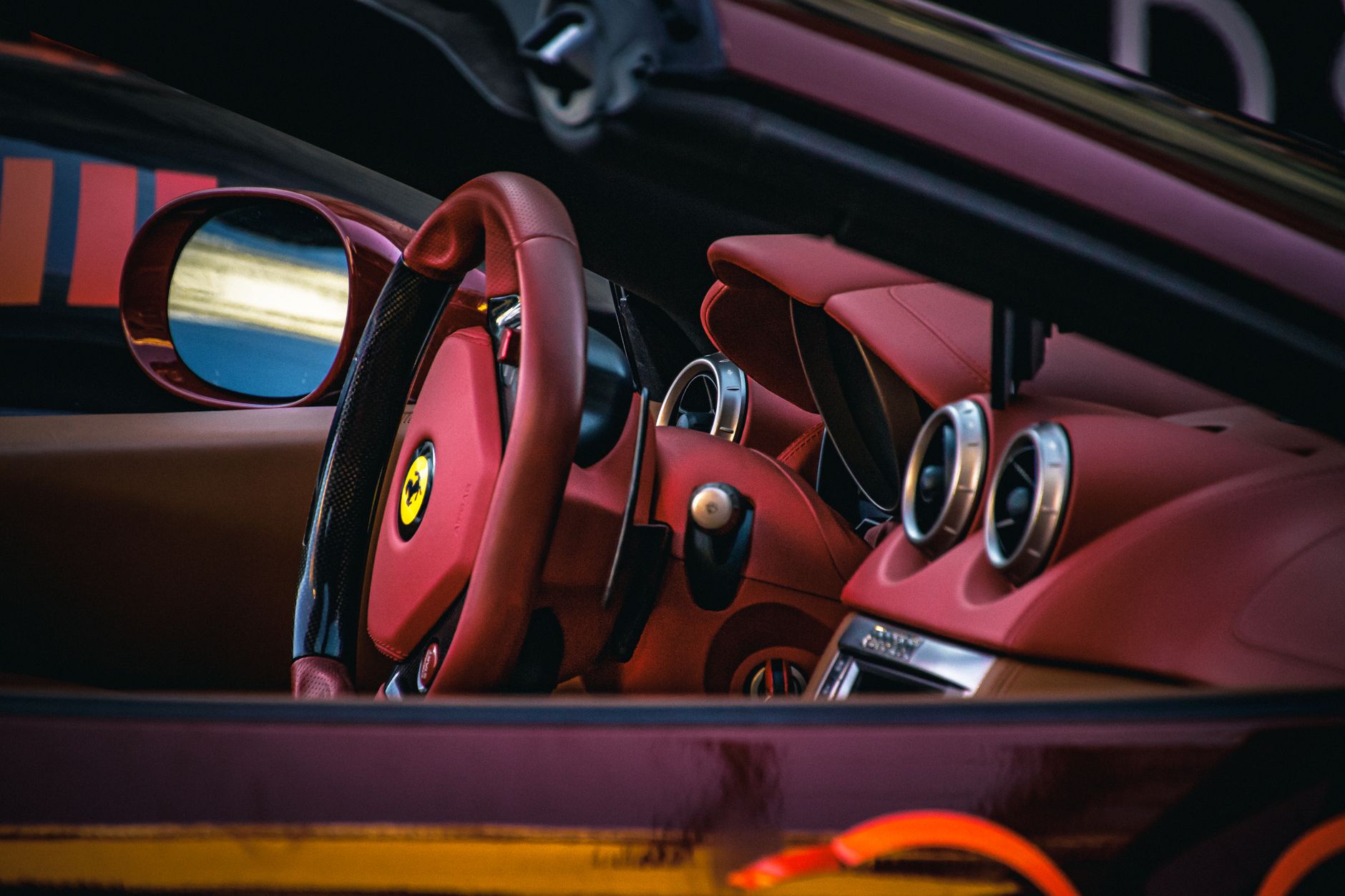 Wnętrze Lamborghini z czerwonymi skórzanymi fotelami i kierownicą