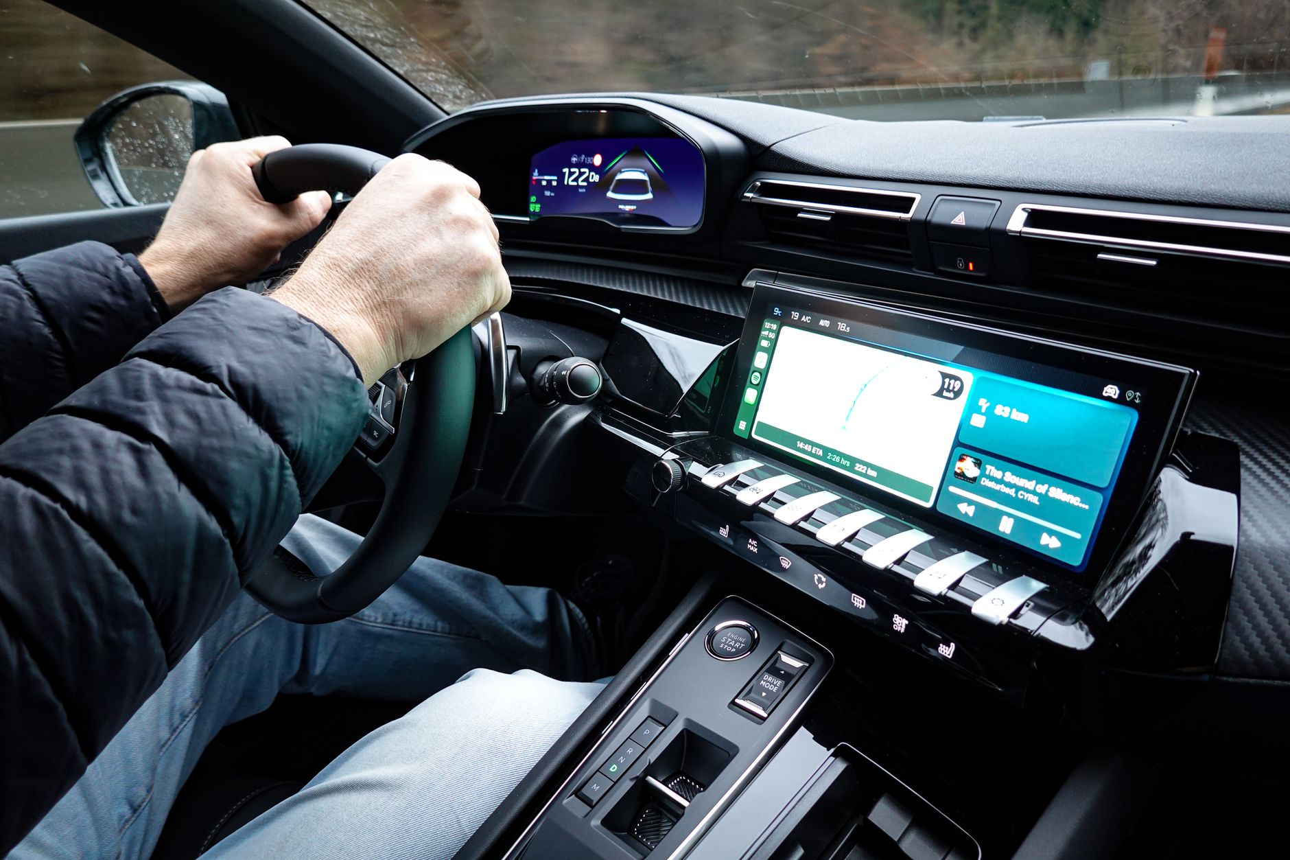Dłonie na kierownicy we wnętrzu nowoczesnego auta Tesla