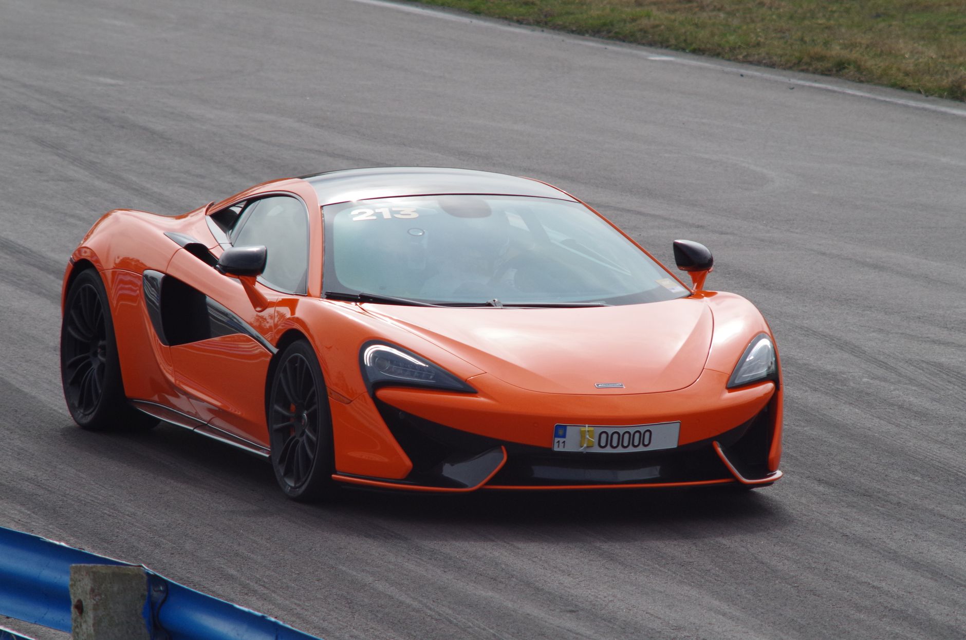 Pomarańczowe Lamborghini Gallardo pędzi po torze wyścigowym w Kijowie