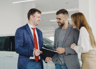 Uśmiechnięta para kupuje nowego Hyundaia u sprzedawcy w salonie