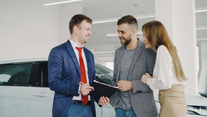 Uśmiechnięta para kupuje nowego Hyundaia u sprzedawcy w salonie Uśmiechnięta para kupuje nowego Hyundaia u sprzedawcy w salonie