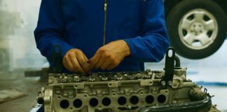Mechanik naprawiający silnik Forda w warsztacie